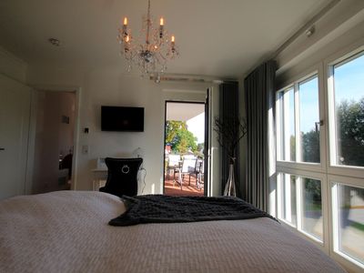 Schlafzimmer mit Doppelbett, TV und Balkon