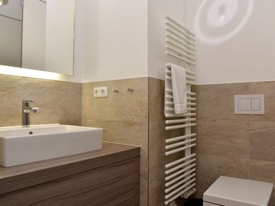 Badezimmer mit Waschbecken, Spiegel, WC und Dusche