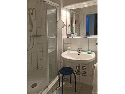 Badezimmer mit Dusche, WC, Spiegel und Waschbecken