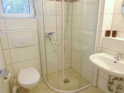 Badezimmer mit Dusche, WC, Spiegel und Waschbecken