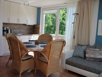 Wohnbereich mit Esstisch, offener Küche und Sofa