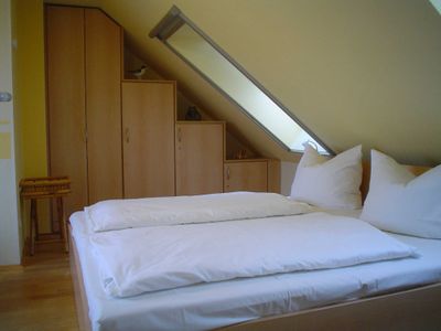 Schlafzimmer mit Doppelbett und Kleiderschrank