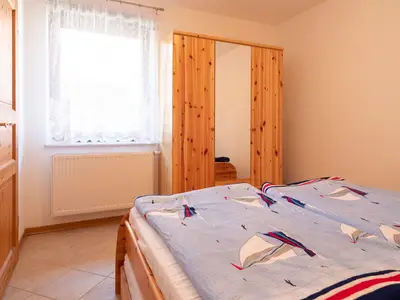 Schlafzimmer mit Doppelbett und Kleiderschrank