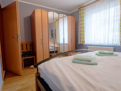 Schlafzimmer mit Doppelbett und Kleiderschrank