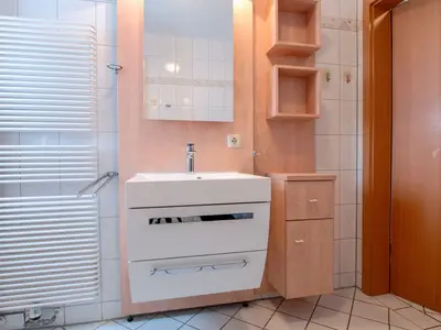 Badezimmer mit Spiegel und Waschbecken