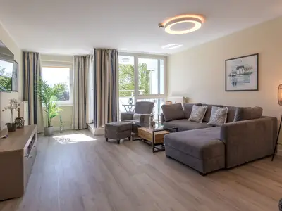 Ferienwohnung Godewind Blick ins offene Wohnzimmer mit Couch und Sessel