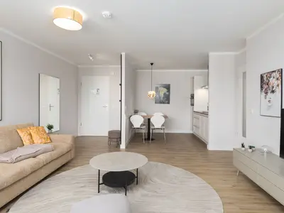 Ferienwohnung Windflüchter Aparthotel Zingst - Wohnzimmer - Blick zur offenen Küche