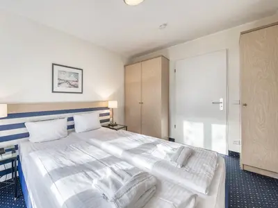 Ferienwohnung Krosse Krabbe Blick ins Schlafzimmer mit gemütlichem Doppelbett und Kleiderschränken