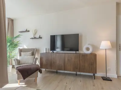Ferienwohnung Küstenglück Aparthotel Zingst - Tv und Sessel im Wohnbereich