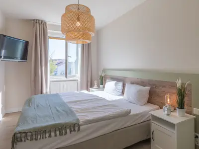 Ferienwohnung Küstenglück Aparthotel Zingst - Schlafzimmer mit Doppelbett und TV