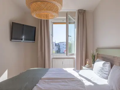 Ferienwohnung Küstenglück Aparthotel Zingst - Blick aus dem fenster des Schlafzimmers und Doppelbett mit TV