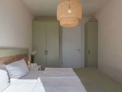 Ferienwohnung Küstenglück Aparthotel Zingst - Blick ins Schlafzimmer mit Doppelbett und Kleiderschrank