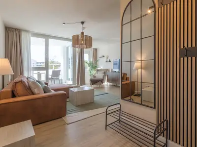 Ferienwohnung Küstenglück Aparthotel Zingst - Blick in das offene Wohnzimmer mit Balkon