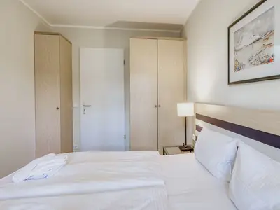Ferienwohnung Ostseeanker in Zingst Schlafzimmer mit Doppelbett und Kleiderschränken