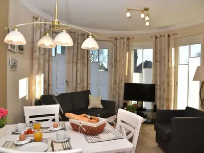 Esstisch mit Bestuhlung und Blick in den Wohnbereich