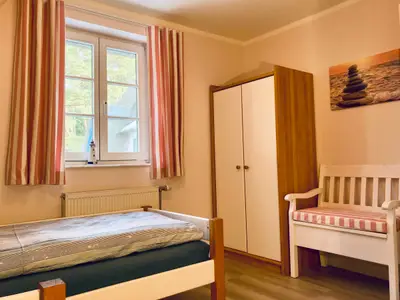 Schlafzimmer mit Einzelbetten und Kleiderschrank
