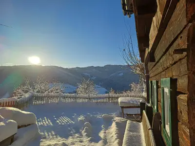 Wintersonne auf der Terrasse der Almhütte Brandgut