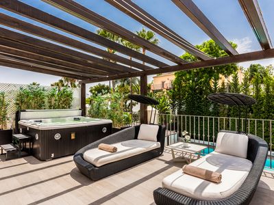 Terrasse im ersten Stock mit Jacuzzi und gemütlichen Sofas