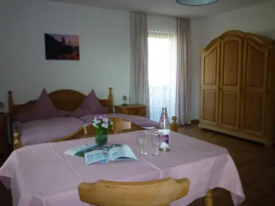 Das Dreibettzimmer bietet ausreichend Platz und eine nette Sitzgelegenheit