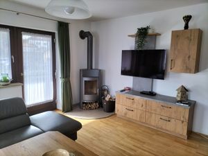 Das gemütliche Wohnzimmer mit Schwedenofen und direktem Zugang zum Balkon