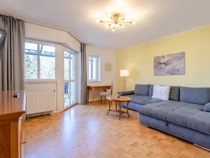 Wohnzimmer mit Schreibtisch und Balkon