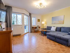 Wohnzimmer mit Schreibtisch und Balkon