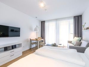 Wohn/Essbereich mit Doppelbett, Couch, Esstisch und TV
