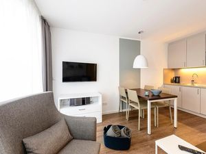 Wohn/Essbereich mit Sessel, Esstisch, Küchenzeile und TV