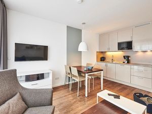 Wohn/Essbereich mit Sessel, Esstisch, Küchenzeile und TV