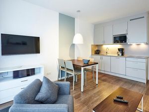 Wohn/Essbereich mit Sessel, Esstisch, TV und Küchenzeile