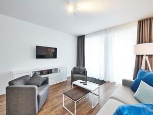 Wohnbereich mit Couch, Sesseln und Flatscreen-TV
