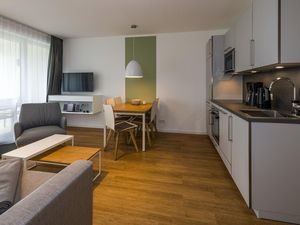 Wohn-Essbereich mit Couch, Esstisch, Sitzgelegenheit und Küchenzeile