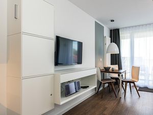 Wohn-Ess-Schlafbereich mit Couch und Flatscreen-TV
