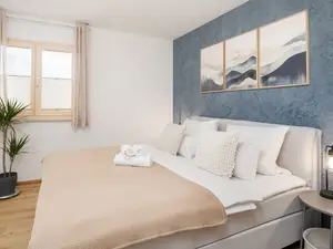 Für einen erholsamen Schlaf sorgt im kleinen Schlafzimmer ein 1,80m Boxspringbett mit gemütlicher Bettwäsche.