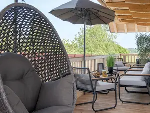 Der geräumige Balkon bietet mit Loungemöbeln, Hängesessel und Liegestühlen  genügend Sitzgelegenheiten im Freien an.