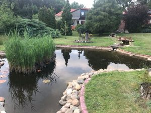 Außenansicht des Gebäudes. Blick auf das Ferienhaus durch den Garten