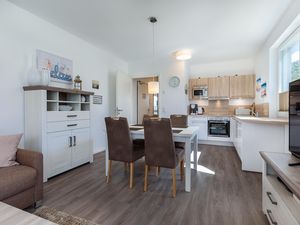 Wohn-/Essbereich mit Esstisch, Sitzgelegenheiten und Küche
