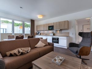 Wohn-/Essbereich mit Doppelschlafcouch, Couchtisch, Sessel und Küchenzeile
