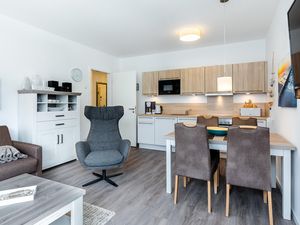 Wohn-/Essbereich mit Couchtisch, Sitzgelegenheiten und Küchenzeile