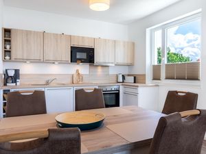 Wohn-/Essbereich mit Esstisch, Sitzgelegenheiten und Küchenzeile