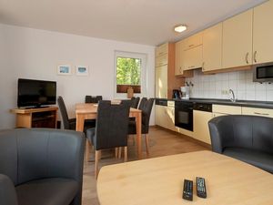 Wohn/Essbereich mit Couch, Kaminofen und Küchenzeile