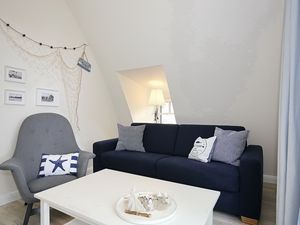 Wohnzimmer mit Schlafcouch und Sessel
