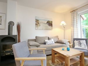 Wohnzimmer mit Sofa, Sesseln und Kamin