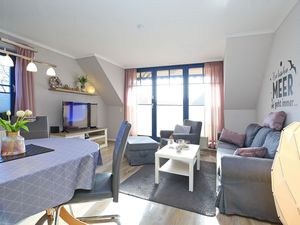 Sofa, Sessel, Hocher und TV im Wohnzimmer