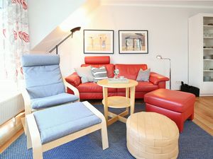 Wohnzimmer mit Sofa, Relaxsessel und Hockern