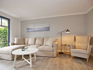 Wohnzimmer mit Ecksofa und Sessel