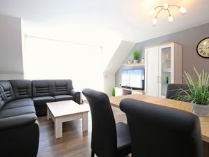 Ecksofa mit TV und Esstisch im Wohnzimmer