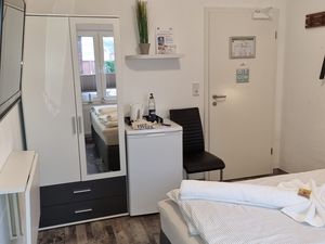 Schlafzimmer mit Kühlschrank und TV