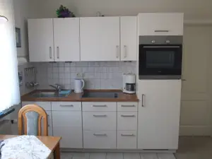 Die Küchenzeile mit Geschirrspüler, Backofen, Cerankochfeld (4) und Kühlschrank m. Gefrierfach