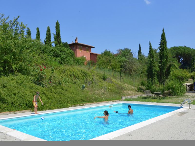 Der gemeinschaftlich genutzte Pool und die große Grünfläche, die ihn umgibt